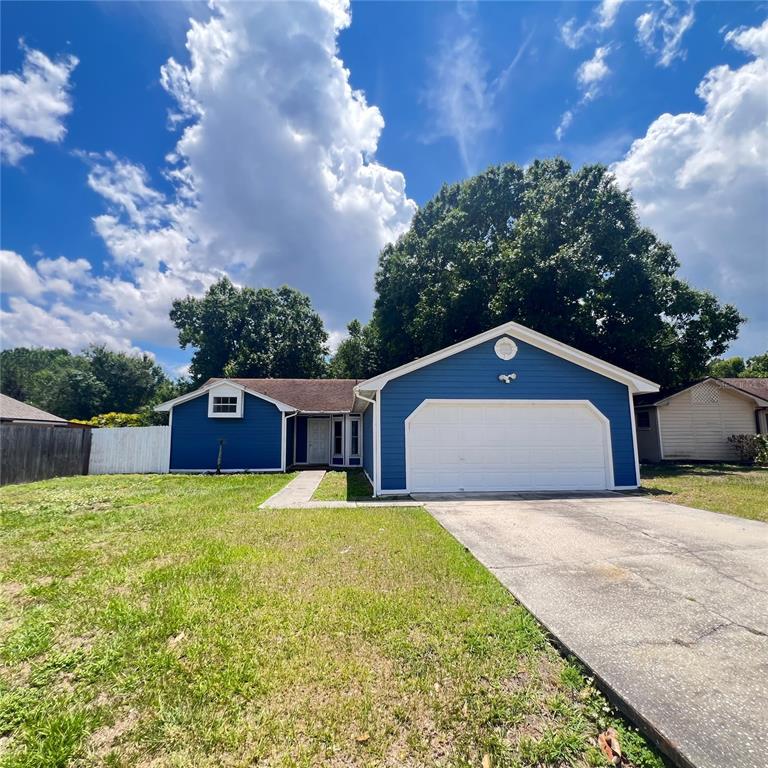 A blue single-story house with a white garage door and a concrete driveway — 3430 FOX RIDGE STREET, WINTER HAVEN, FL