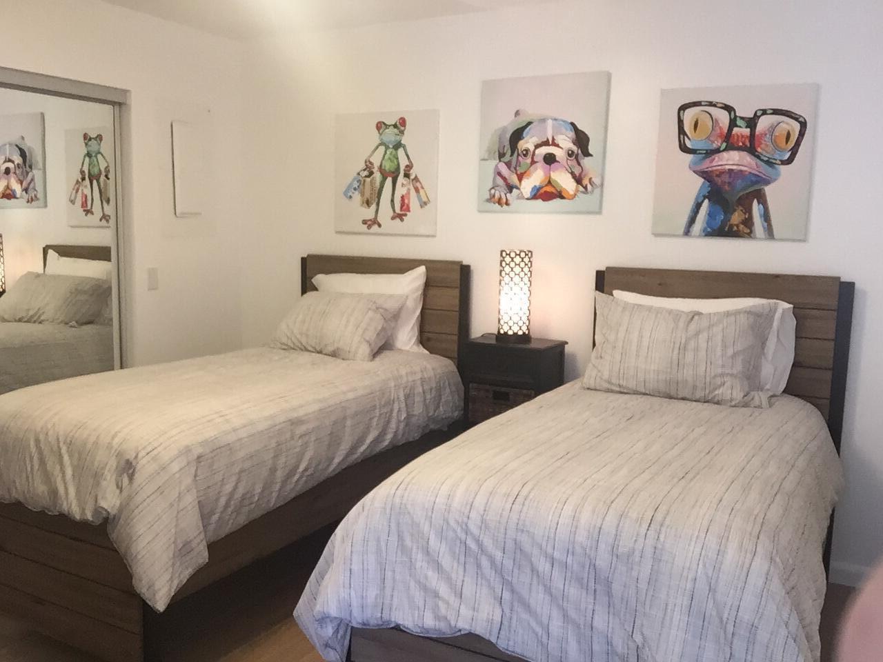 A bedroom with two twin beds, a shared nightstand, and colorful animal wall art — 1605 S Us Hwy One, Jupiter FL 33477, JUPITER, FL