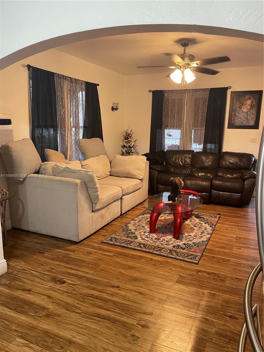 A living room features a beige sofa, a dark brown leather sofa, and a glass coffee table — 404 NW 23rd Ct, Miami FL 33125, MIAMI, FL