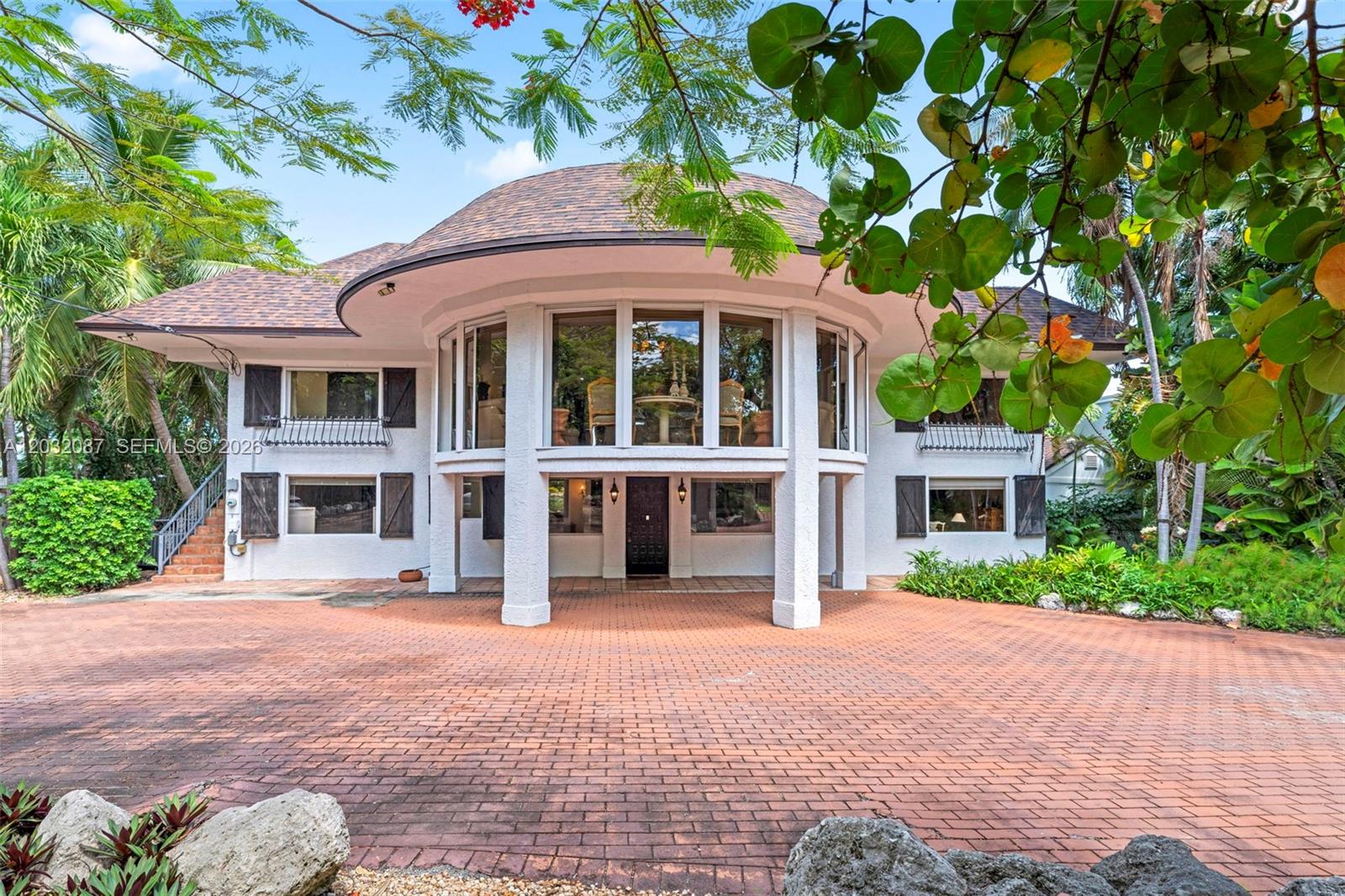 A two-story house with a circular upper section, large windows, and a brick driveway — 88110 Overseas Hwy, Islamorada FL 33036, ISLAMORADA, FL