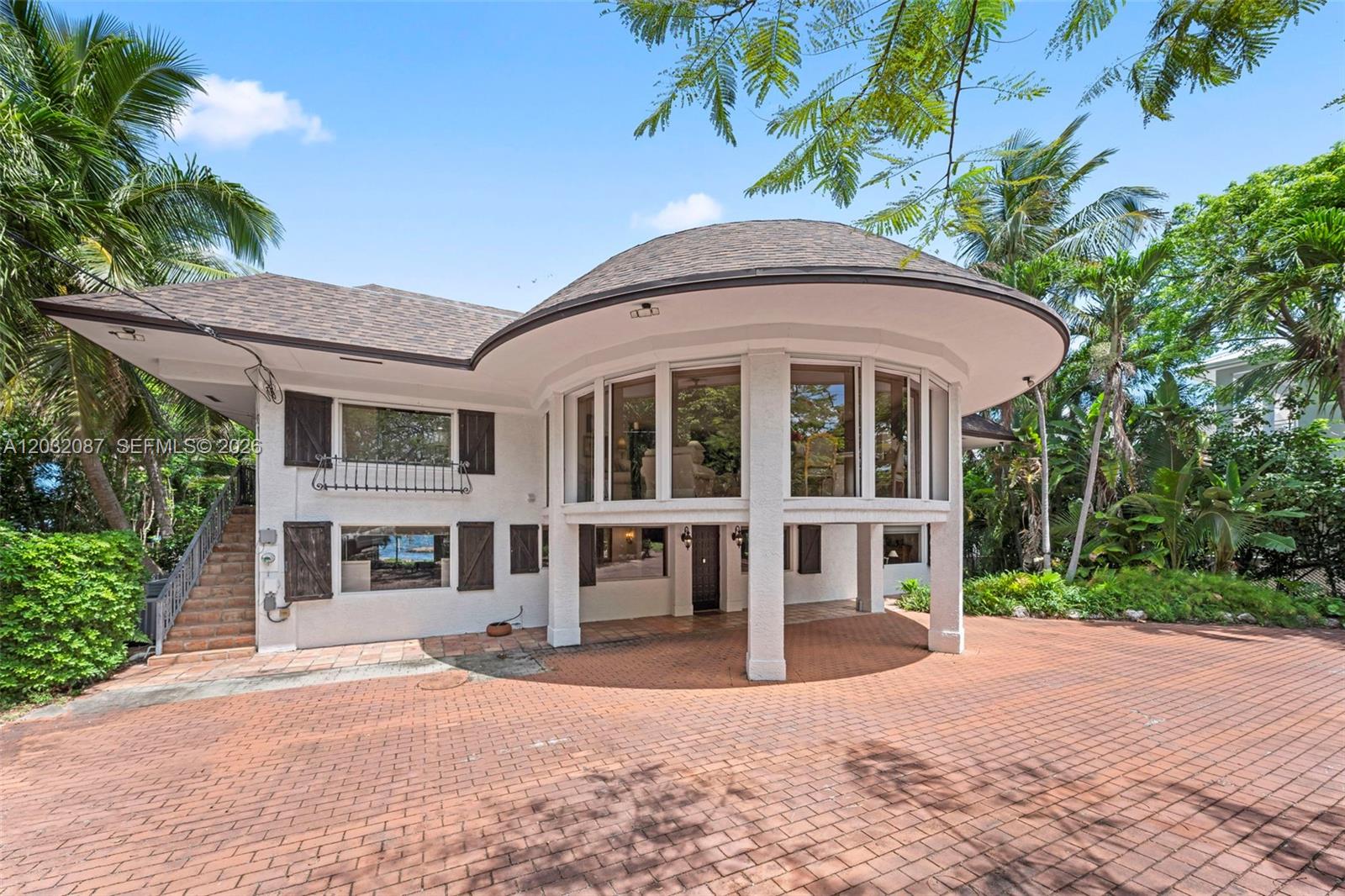 A two-story house with a circular, elevated glass-walled section and a brick-paved driveway — 88110 Overseas Hwy, Islamorada FL 33036, ISLAMORADA, FL