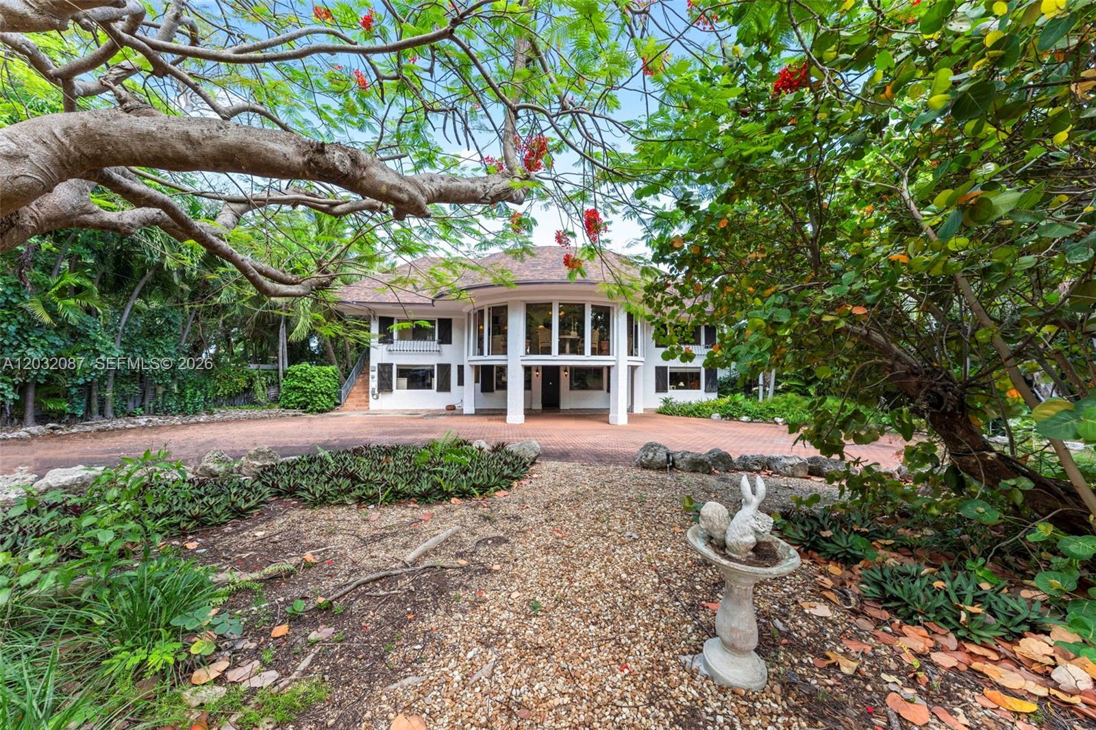 A two-story white house with a large arched window facade sits behind a gravel garden — 88110 Overseas Hwy, Islamorada FL 33036, ISLAMORADA, FL
