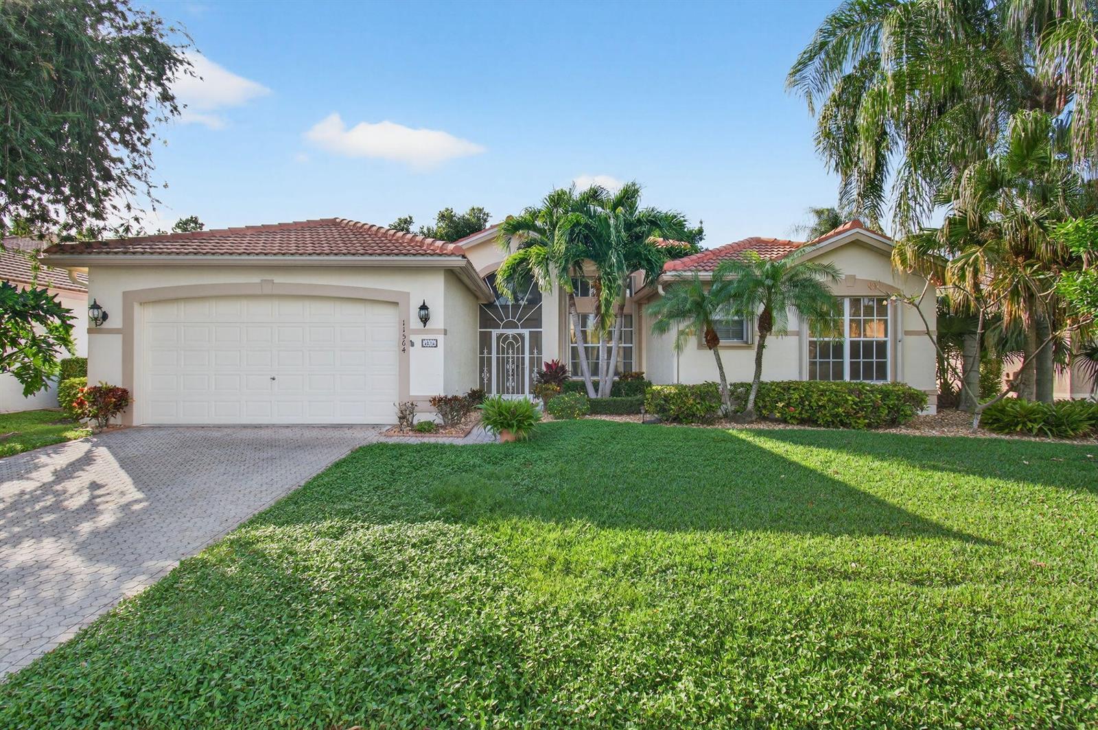 A single-story house with a tiled roof, a two-car garage, and a landscaped front yard — 11564 Puerto Boulevard, Boynton Beach FL 33437, BOYNTON BEACH, FL