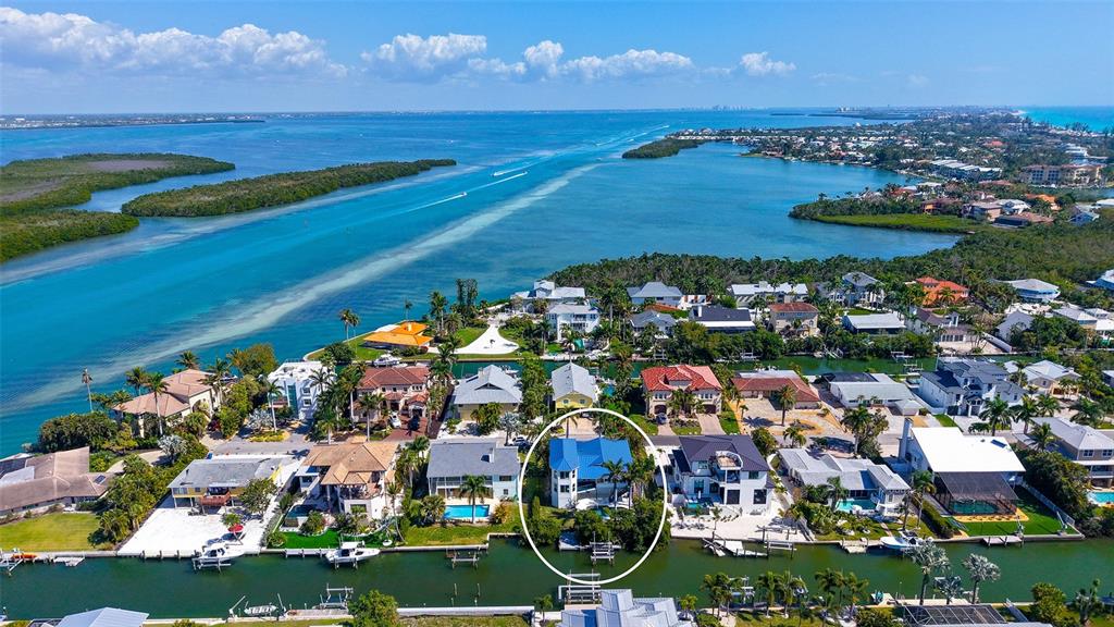 An aerial view shows a house with a blue metal roof near a canal — 771 MARBURY LANE, LONGBOAT KEY, FL