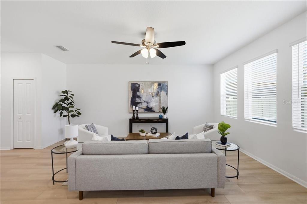 A living room features a gray sofa, two white armchairs, and a ceiling fan — 5718 LOS ROBLES COURT, PALMETTO, FL
