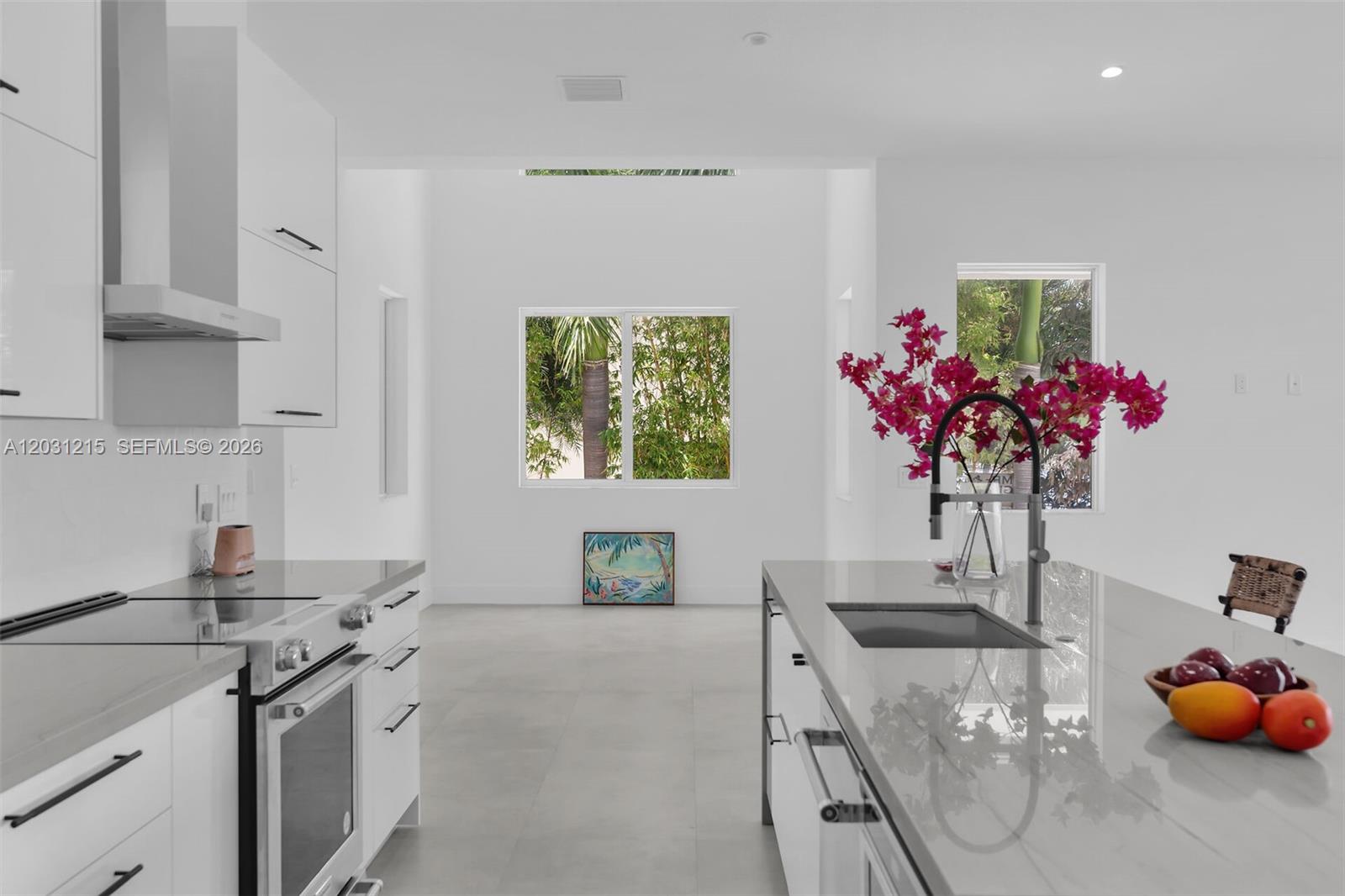A modern white kitchen features a large island with a sink and grey countertops — 38 N Bounty Ln, Key Largo FL 33037, KEY LARGO, FL