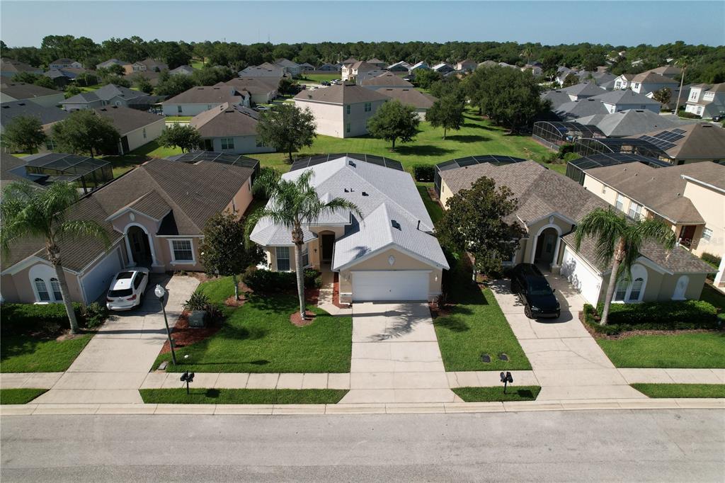 An aerial view shows a suburban street with three single-family homes and manicured lawns — 189 MINNIEHAHA CIRCLE, HAINES CITY, FL
