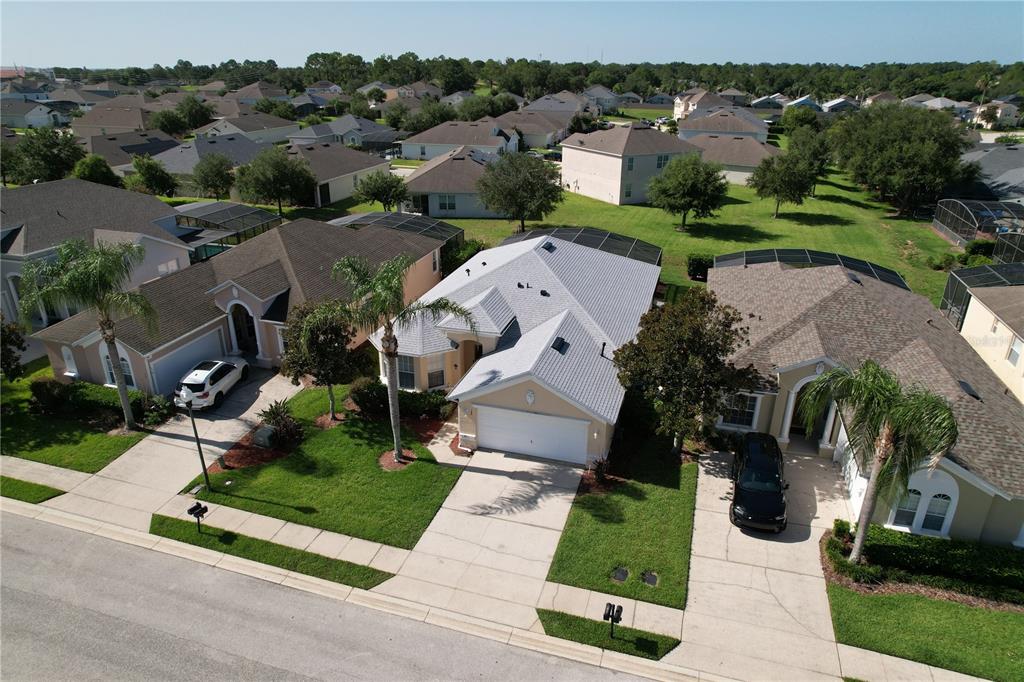 An aerial view shows three suburban houses with driveways, lawns, and screened-in back patios — 189 MINNIEHAHA CIRCLE, HAINES CITY, FL