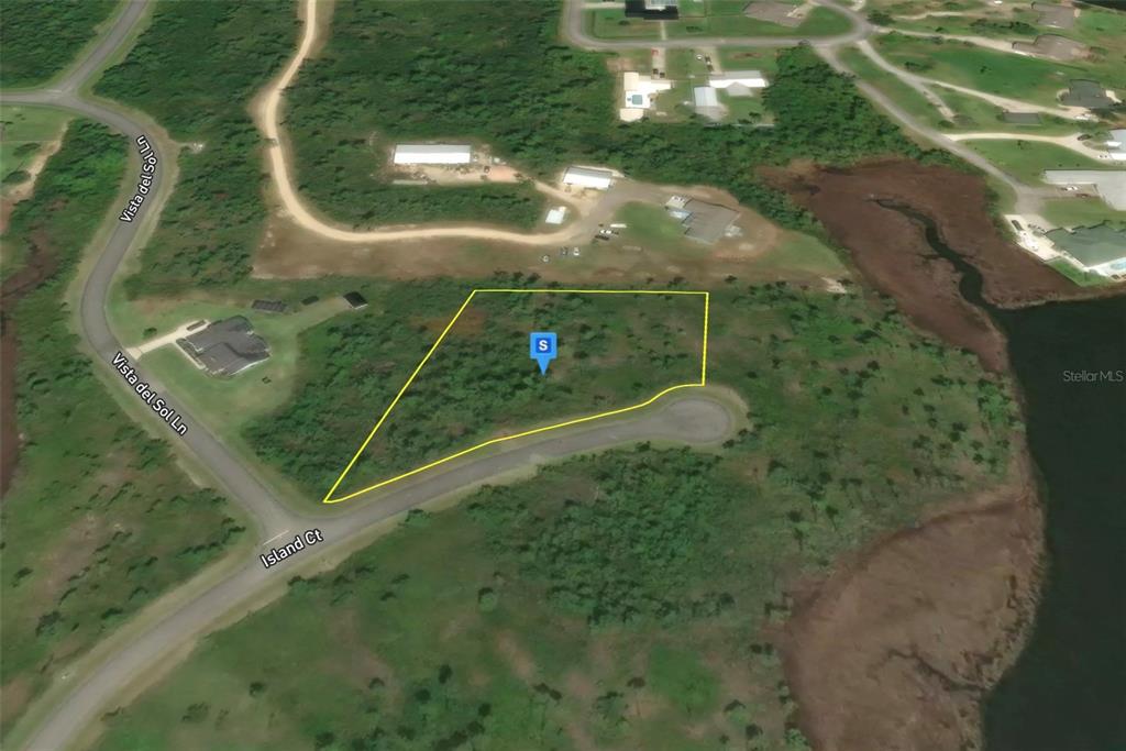 This is an aerial map view of a vacant, undeveloped lot outlined in yellow — 702 ISLAND COURT, PANAMA CITY, FL