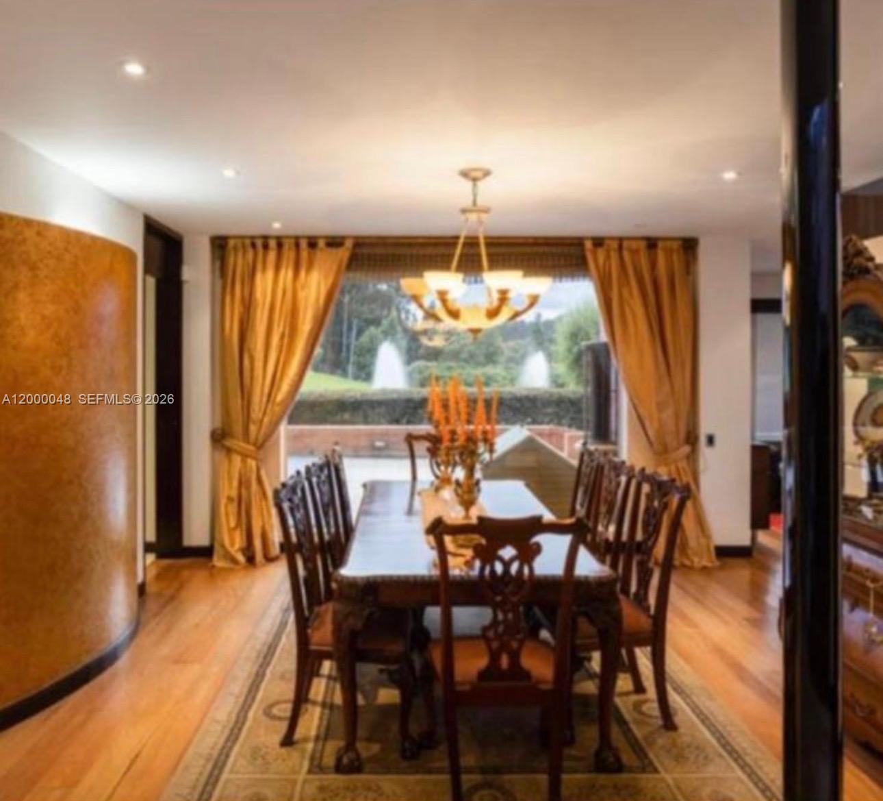 A formal dining room features a long wooden table, ornate chairs, and large gold curtains — Aposentos Autopista Norte Km 33, FL