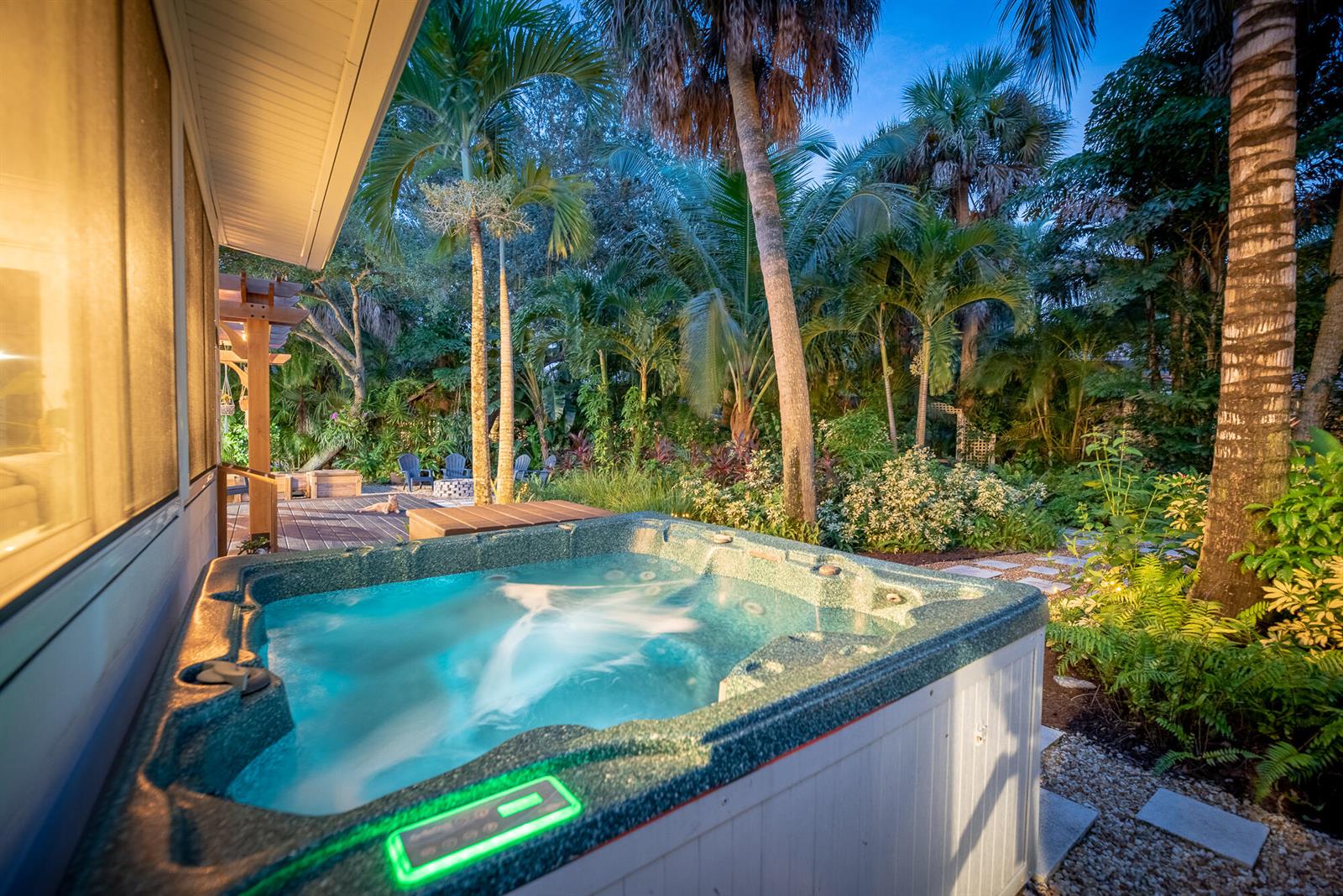 A hot tub sits on a patio next to a house surrounded by tropical landscaping — 547 SW Riverview Street, Stuart FL 34994, STUART, FL