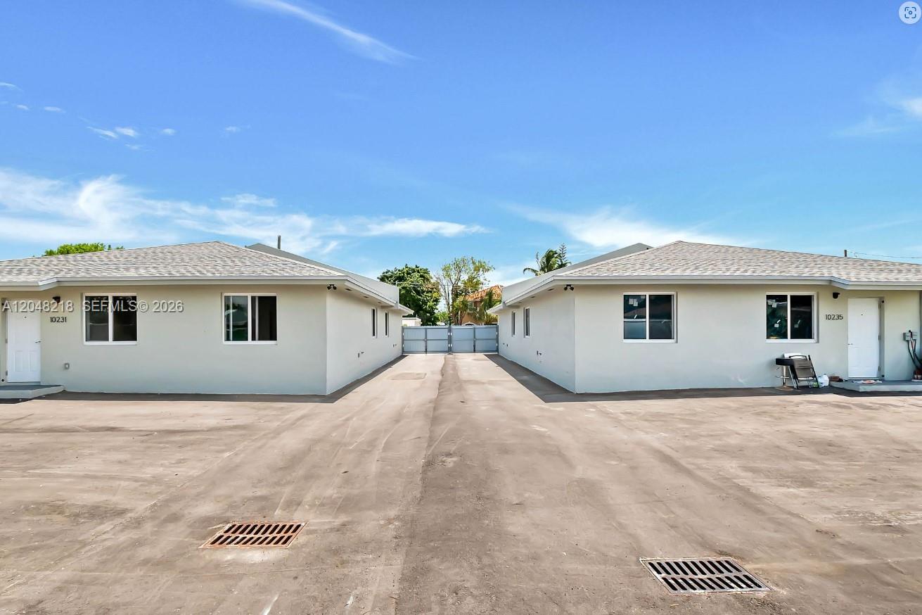 Two single-story buildings face each other across a paved driveway with a metal gate — 10235 SW 173rd St # 10235, Miami FL 33157, MIAMI, FL