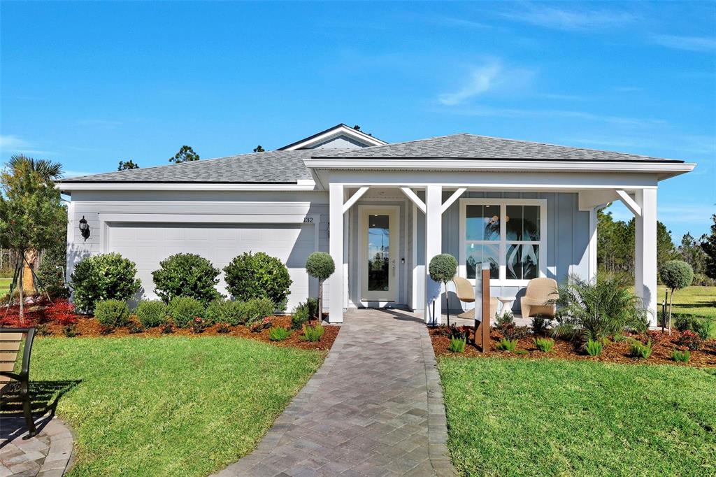 A single-story house with a white exterior, a covered front porch, and a paved walkway — 339 FISHTAIL PLACE, PALM COAST, FL