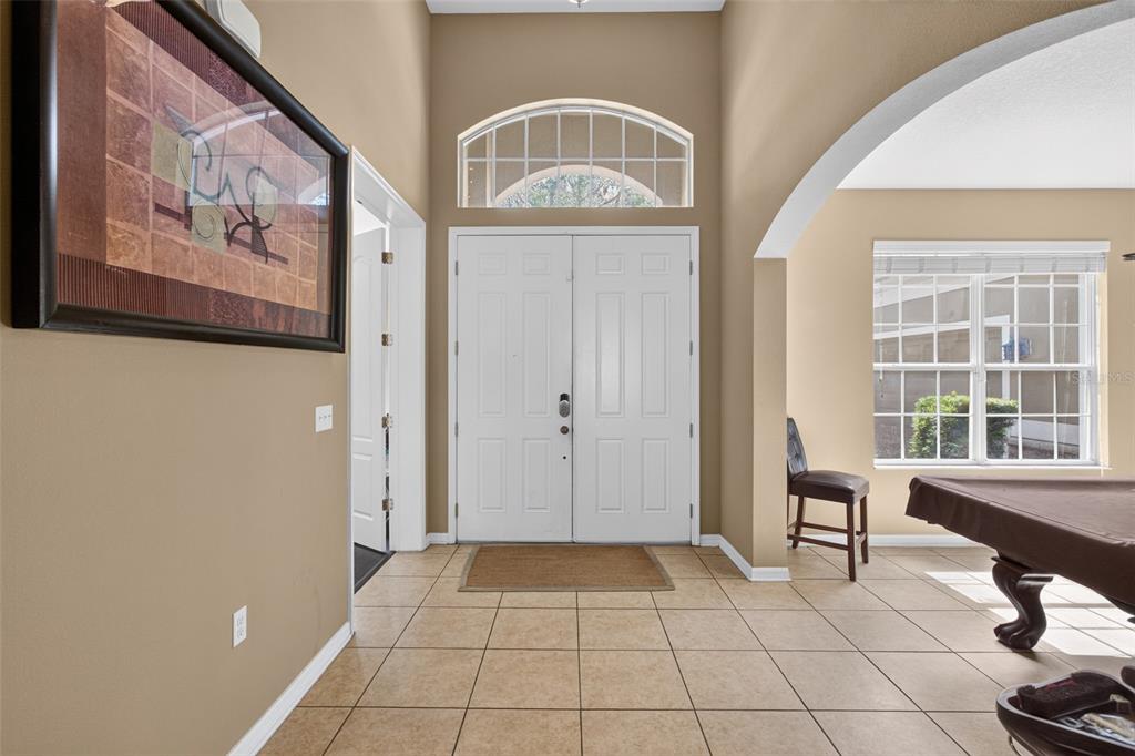 A room with tile floors features a covered pool table and a three-light pendant fixture — 2516 WOODSIDE RIDGE DRIVE, APOPKA, FL