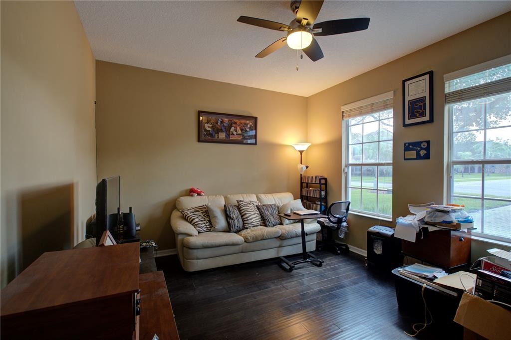 A living room with dark wood floors, a beige sofa, and a ceiling fan — 2516 WOODSIDE RIDGE DRIVE, APOPKA, FL