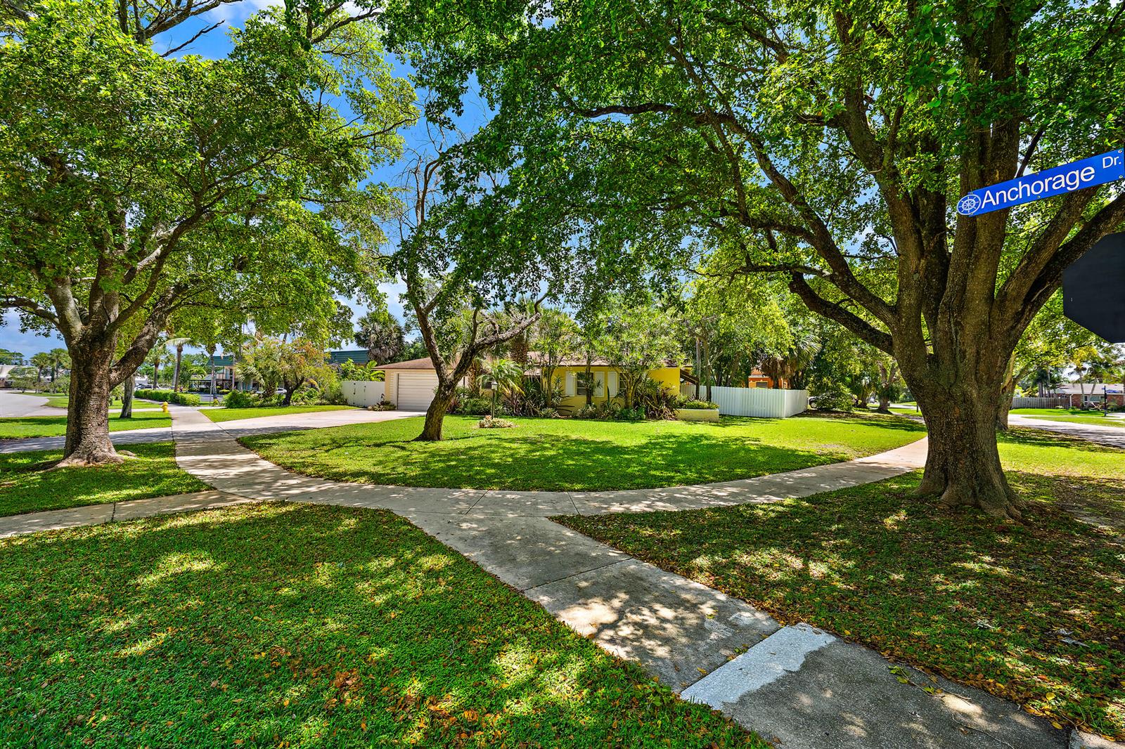 A sidewalk forks in front of a house surrounded by large trees and green grass — 844 Anchorage Drive, North Palm Beach FL 33408, NORTH PALM BEACH, FL