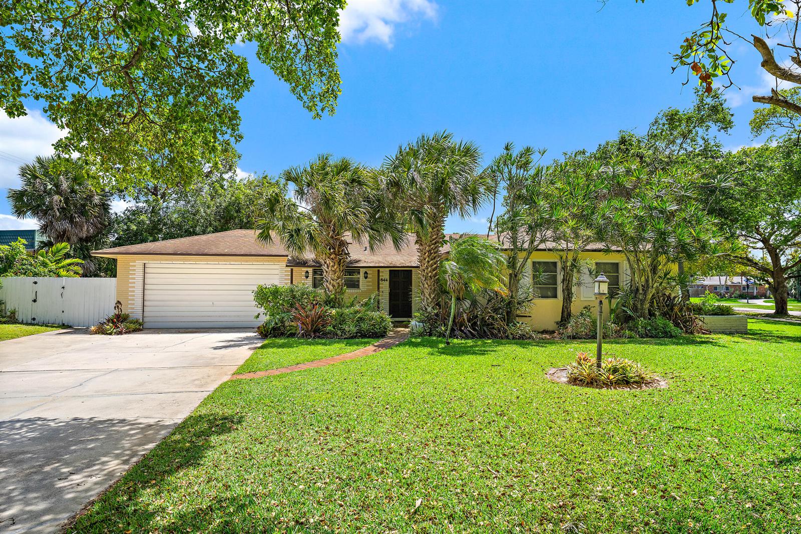A single-story house with a two-car garage, palm trees, and a brick walkway — 844 Anchorage Drive, North Palm Beach FL 33408, NORTH PALM BEACH, FL