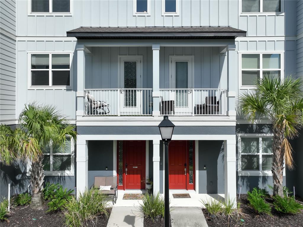 An exterior view of a multi-story residential building featuring a balcony with a red star — 3427 NORMAN LEWIS ALLEY, ORLANDO, FL