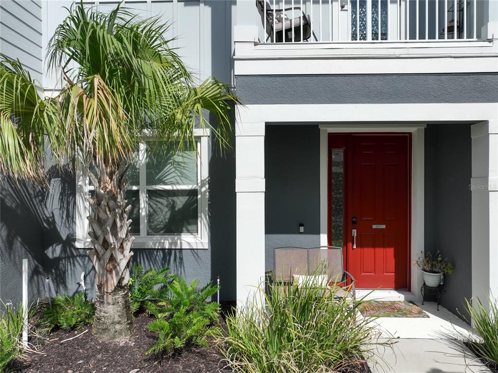 A two-story building exterior features two red front doors and a shared second-floor balcony — 3427 NORMAN LEWIS ALLEY, ORLANDO, FL