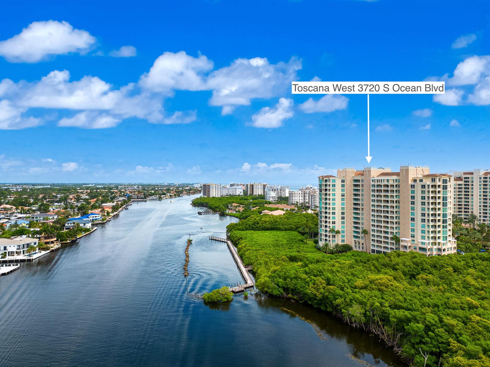An aerial view shows a tall residential building situated next to a waterway and mangroves — 3720 S Ocean Boulevard, Highland Beach FL 33487, HIGHLAND BEACH, FL