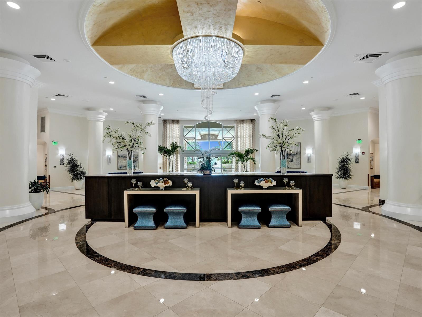 A grand hotel lobby features a large crystal chandelier, marble floors, and a dark reception desk — 3720 S Ocean Boulevard, Highland Beach FL 33487, HIGHLAND BEACH, FL