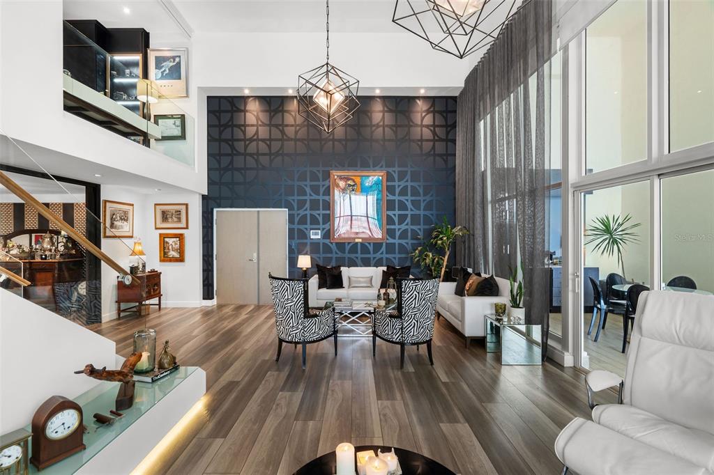 A modern, high-ceilinged living room features a dark patterned accent wall and zebra-print armchairs — 25 LUIS MUNOZ RIVERA UNIT 408, SAN JUAN, PR