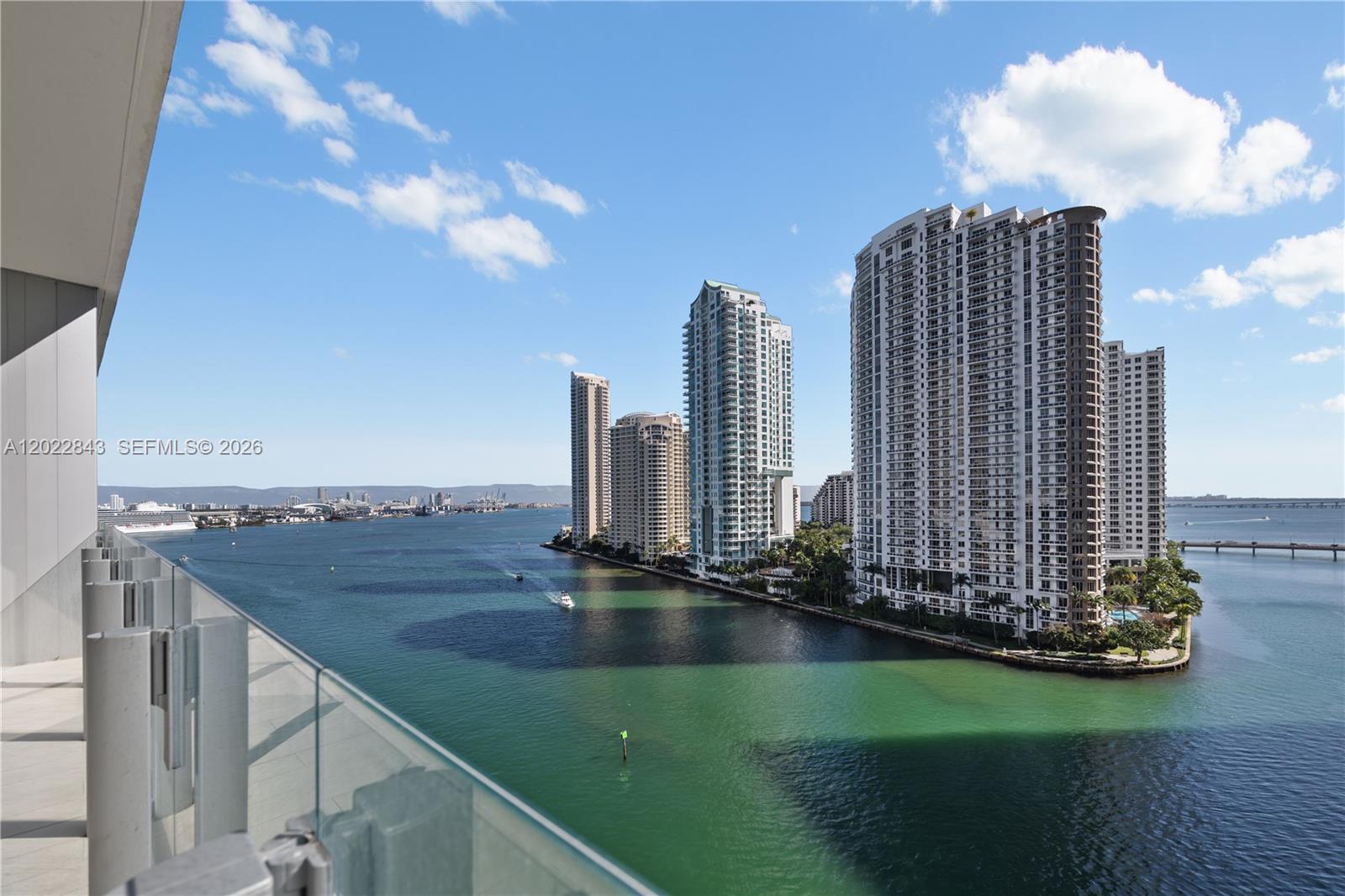 A high-rise balcony overlooks a bay with several tall residential buildings and a cruise ship — 300 Biscayne Blvd Way # 1102, Miami FL 33131, MIAMI, FL