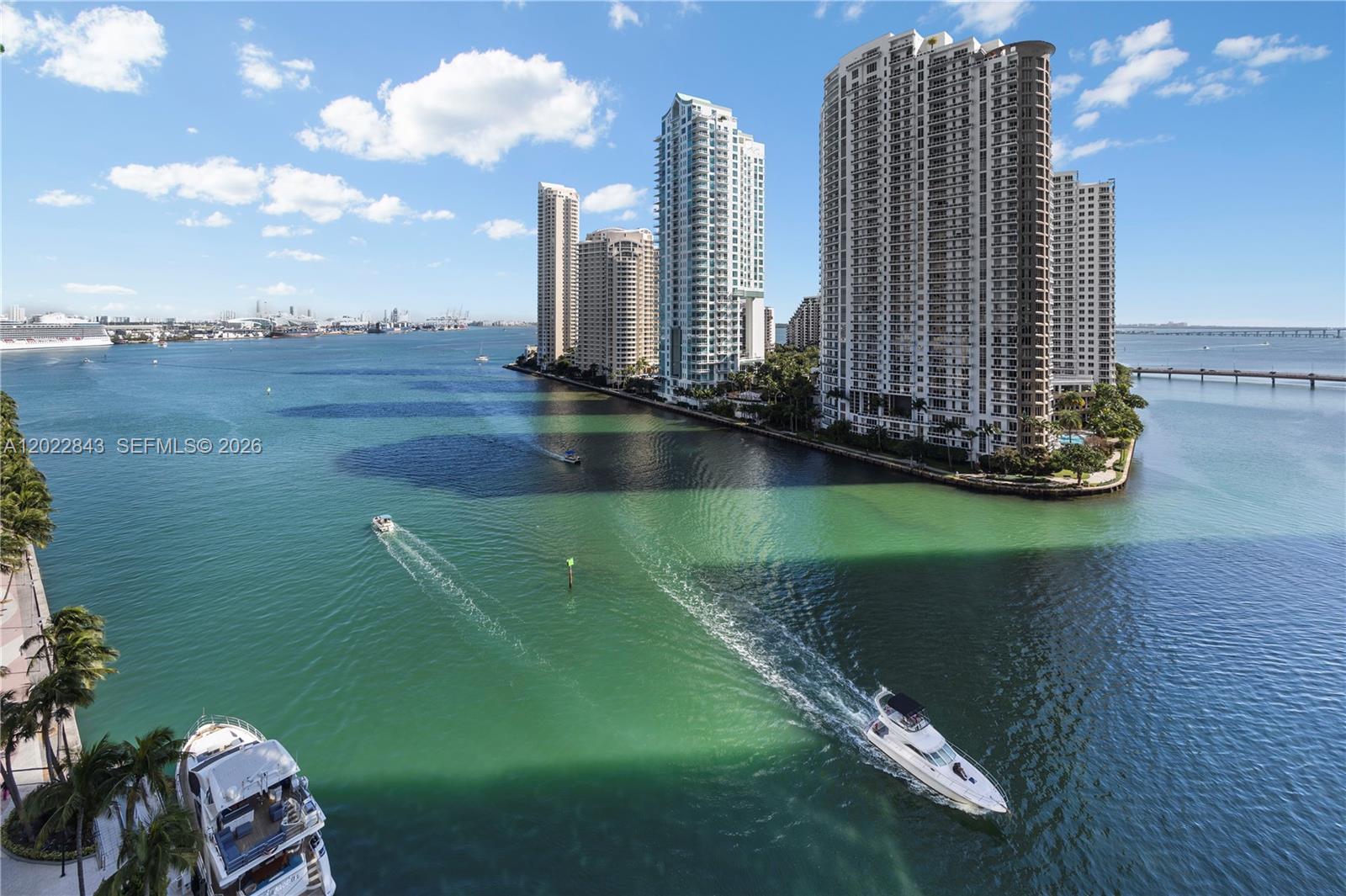 An aerial view shows a waterway with boats and high-rise apartment buildings along the shore — 300 Biscayne Blvd Way # 1102, Miami FL 33131, MIAMI, FL