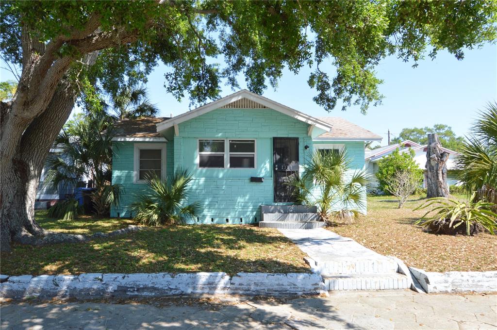 A light green, single-story house with a brick facade and a large tree in front — 2351 25TH AVENUE S, ST PETERSBURG, FL