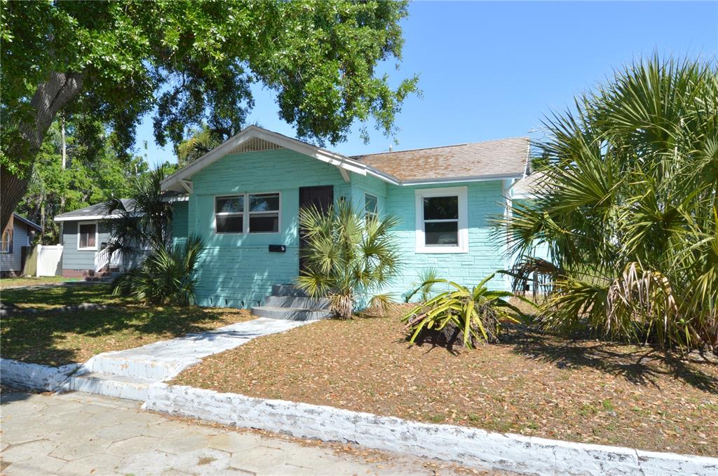 A light green, single-story house with a front walkway and surrounding palm trees — 2351 25TH AVENUE S, ST PETERSBURG, FL