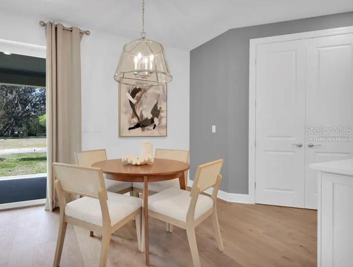 A dining area features a round wooden table, four chairs, a pendant light, and sliding doors — 12071 ORCHID ASH STREET, RIVERVIEW, FL