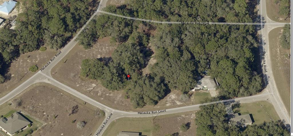 An aerial view shows a wooded residential lot marked with a red pin — TBD MALAUKA RUN COURT, OCKLAWAHA, FL