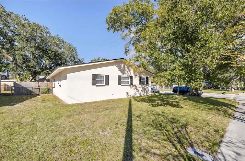 A single-story house with a light-colored exterior and three windows sits on a grassy lot — 1004 N BETTY LANE, CLEARWATER, FL