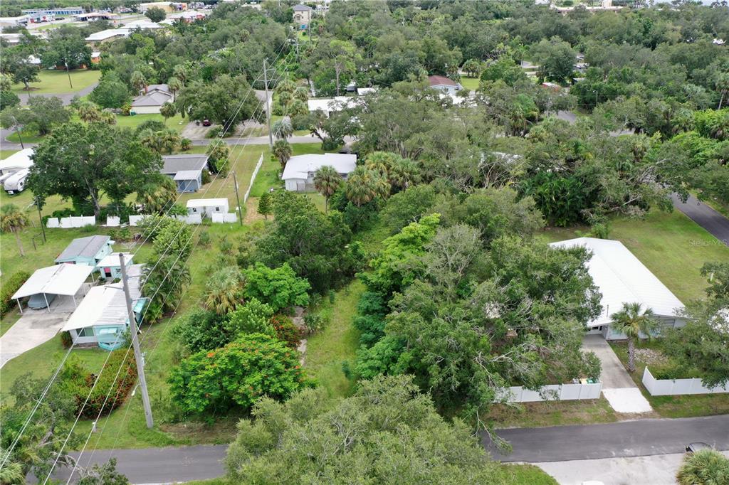 An aerial view shows a wooded residential lot situated between several houses and paved roads — 4466 GANYARD STREET, PUNTA GORDA, FL