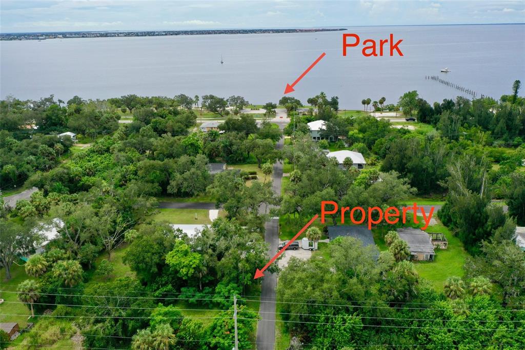 An aerial view shows a residential property located on a road leading toward a waterfront park — 4466 GANYARD STREET, PUNTA GORDA, FL