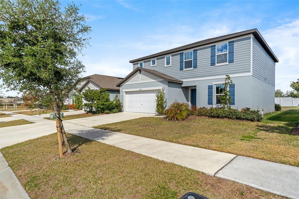A two-story house with blue siding, a white garage, and a front lawn — 9644 SUMMERS CAY CIRCLE, THONOTOSASSA, FL