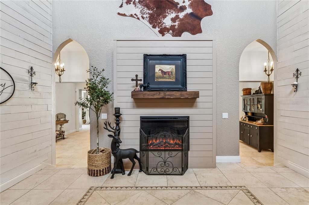 A living room features a shiplap fireplace wall, arched doorways, and a cowhide wall hanging — 3530 OLD KEYSTONE ROAD, TARPON SPRINGS, FL