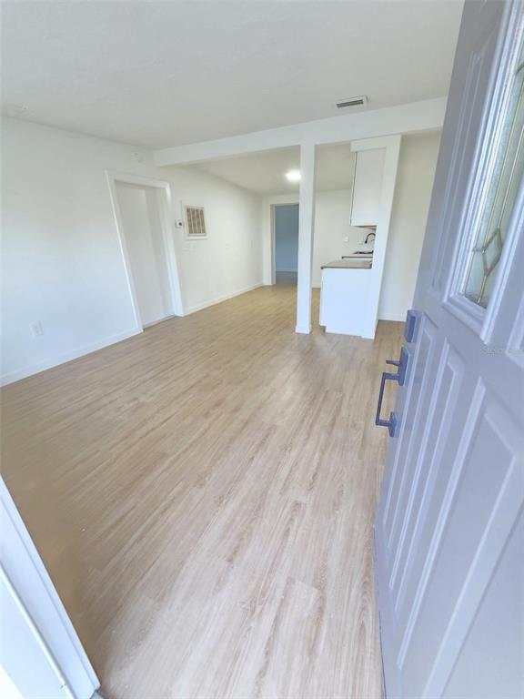 The view from an open doorway shows a living area with light wood-look flooring — 6703 SANDRA DRIVE, PORT RICHEY, FL