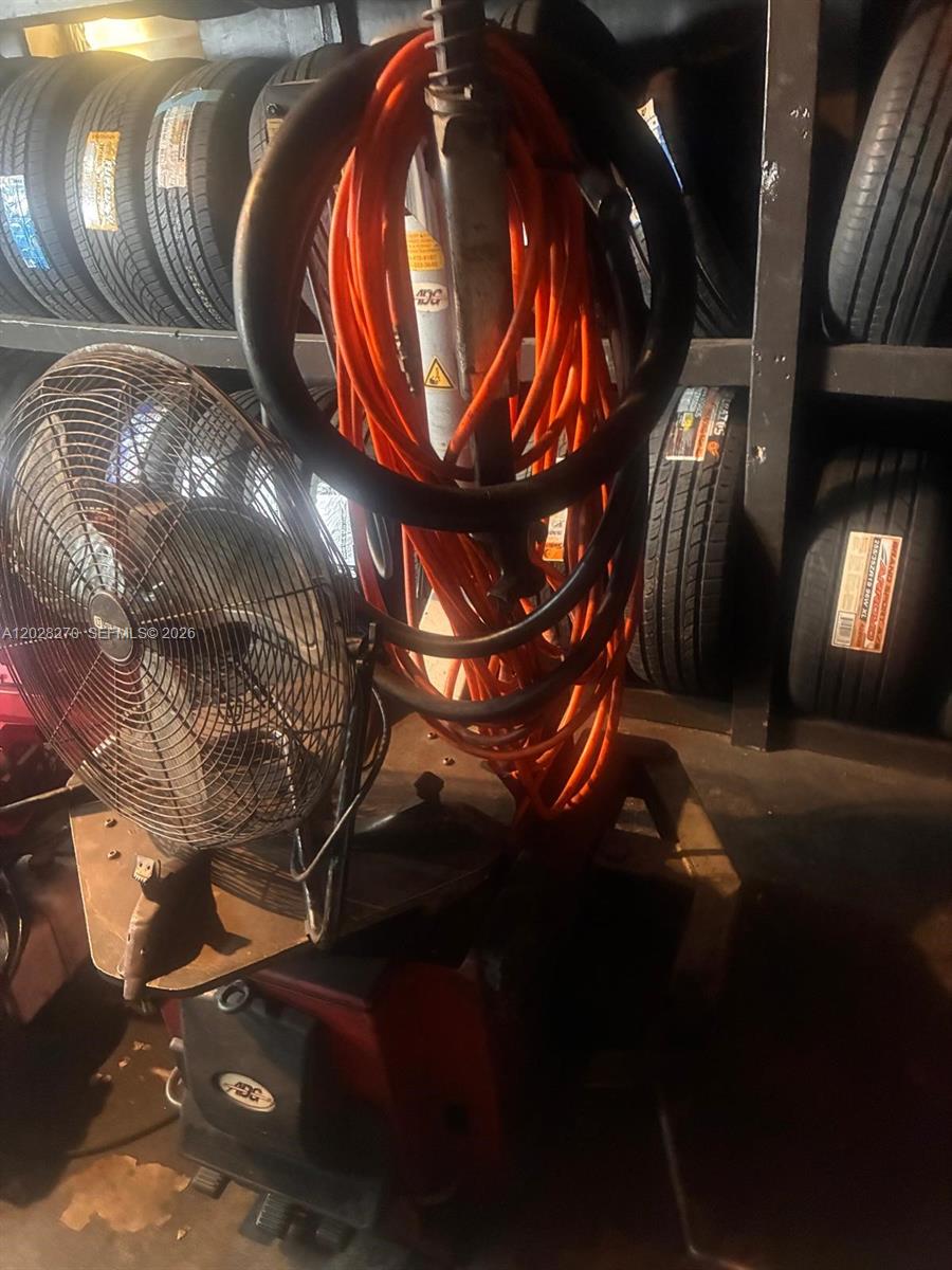A tire changing machine with an orange power cord stands in front of stacked tires — 2337 N 21st Ave, Hollywood FL 33020, HOLLYWOOD, FL