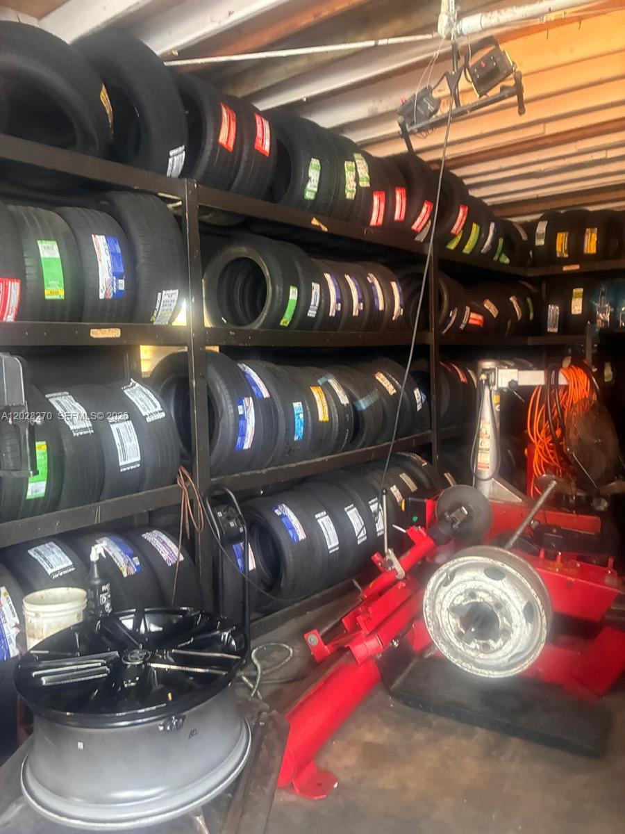 This storage room contains metal shelving units filled with stacked tires and automotive equipment — 2337 N 21st Ave, Hollywood FL 33020, HOLLYWOOD, FL
