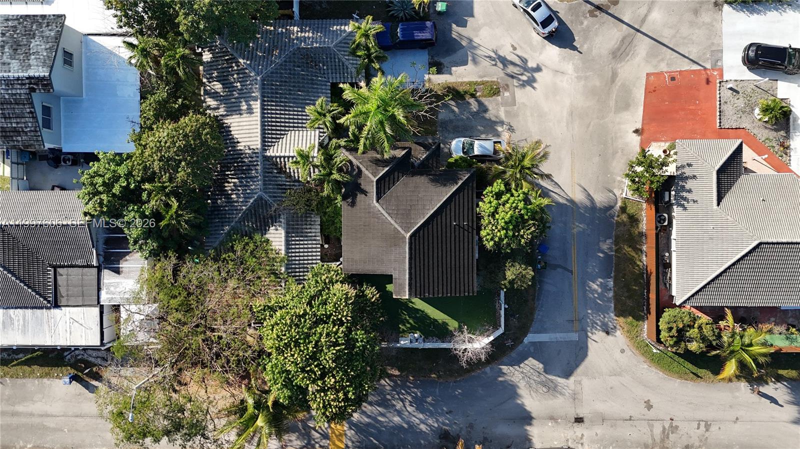 An aerial view shows a residential property with a dark roof and surrounding trees — 18499 NW 52nd Path, Miami Gardens FL 33055, MIAMI GARDENS, FL