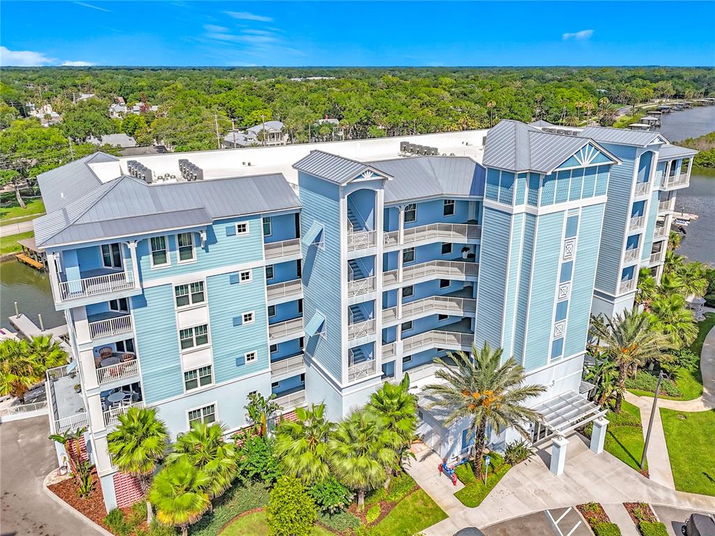 An aerial view of a multi-story blue building with balconies and a metal roof — 3 RIVERWALK DRIVE UNIT 301, NEW SMYRNA BEACH, FL