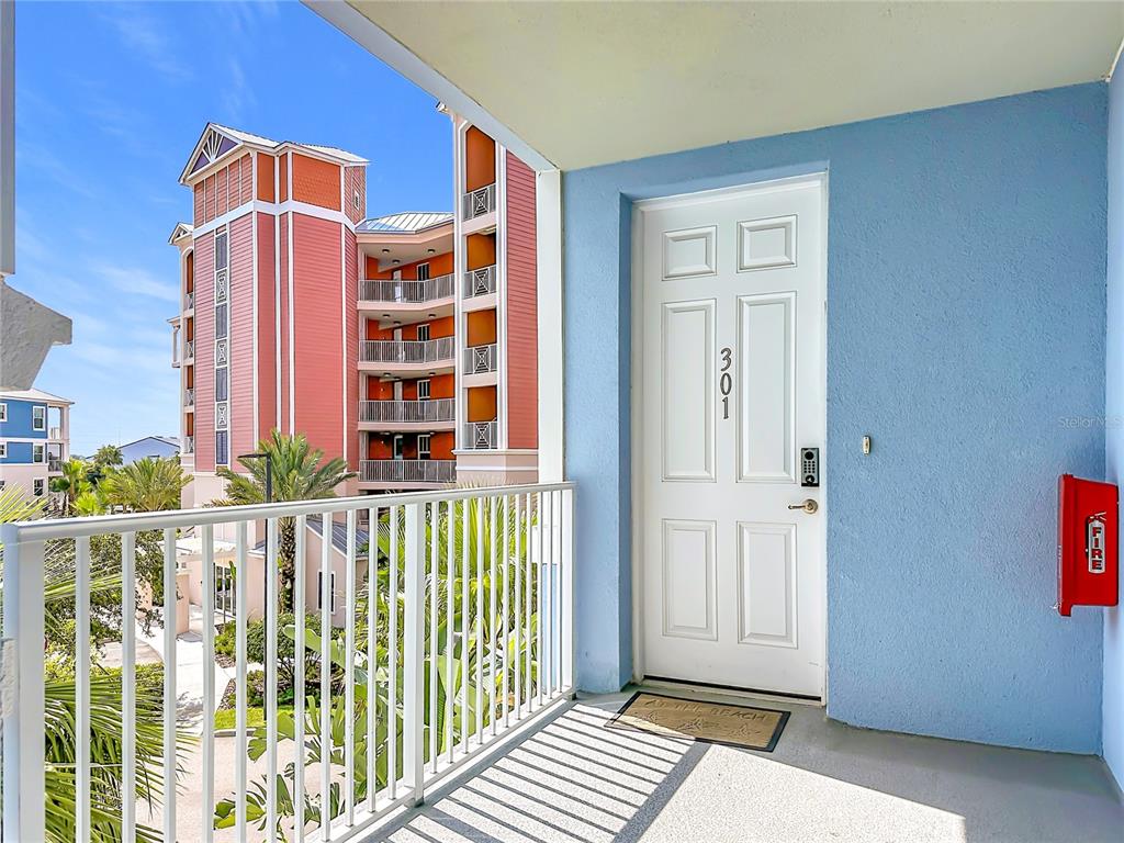 A white door labeled 301 opens onto a balcony overlooking a multi-story building — 3 RIVERWALK DRIVE UNIT 301, NEW SMYRNA BEACH, FL