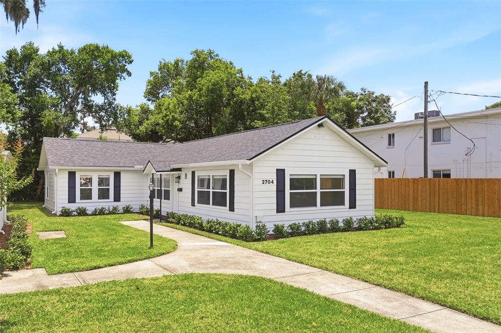 A white single-story house with black shutters and a gray roof sits on a lawn — 2704 E JEFFERSON STREET, ORLANDO, FL