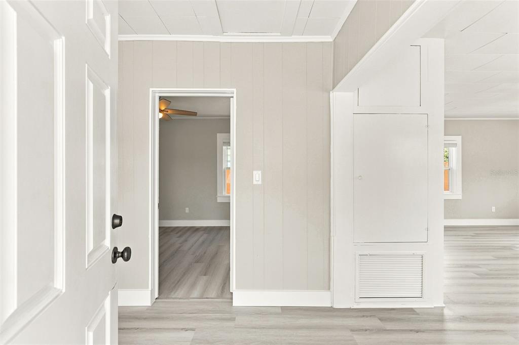 A view from a doorway into a room with light wood-look flooring and paneled walls — 2704 E JEFFERSON STREET, ORLANDO, FL