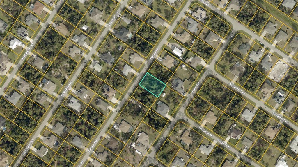 This is an aerial map showing a vacant, wooded residential lot outlined in blue — TOLUCA TERRACE Lot 10 & 11, NORTH PORT, FL