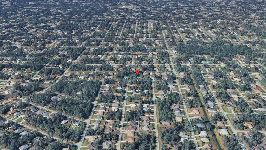 This is an aerial view of a residential neighborhood with many houses and wooded lots — TOLUCA TERRACE Lot 10 & 11, NORTH PORT, FL