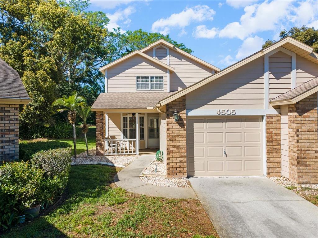 A two-story house with tan siding, a brick facade, and a single-car garage — 4505 GLEN HOLLOW, NEW PORT RICHEY, FL