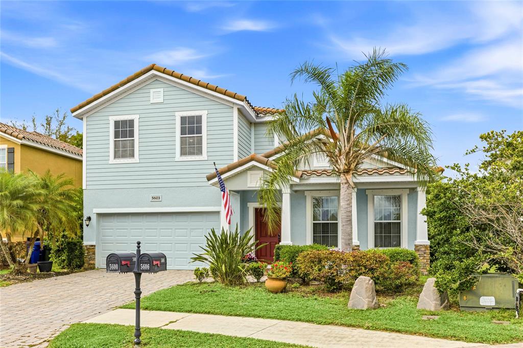 A two-story light blue house with a garage, a palm tree, and two mailboxes — 5603 AARON COURT, SARASOTA, FL