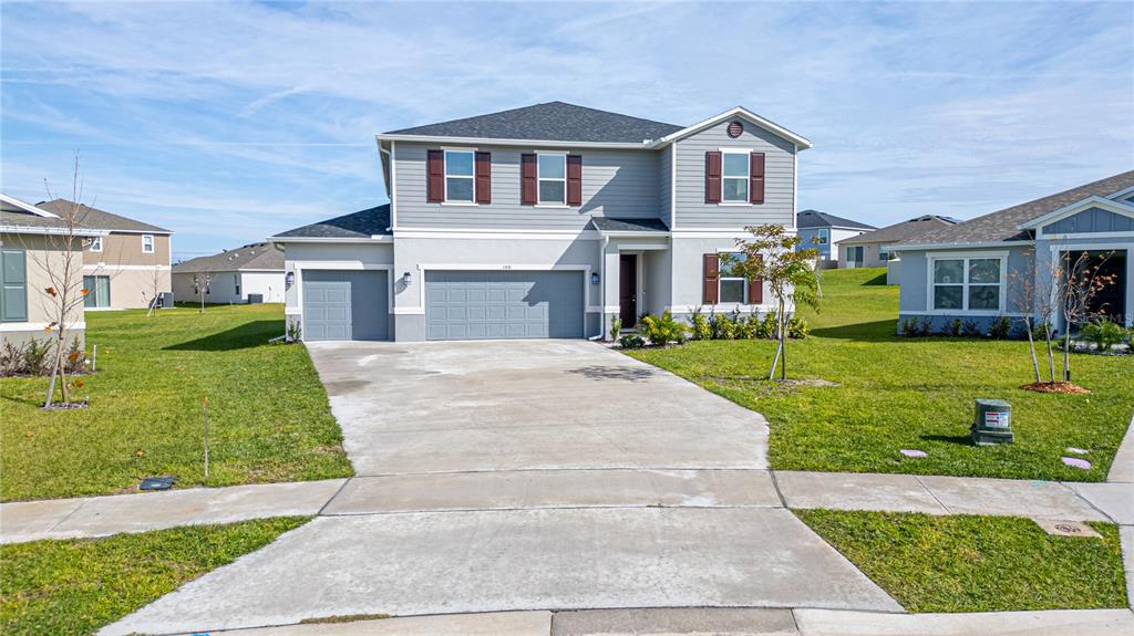 A two-story suburban house with a gray exterior, brown shutters, and a three-car garage — 1531 FUJI COURT, WINTER HAVEN, FL